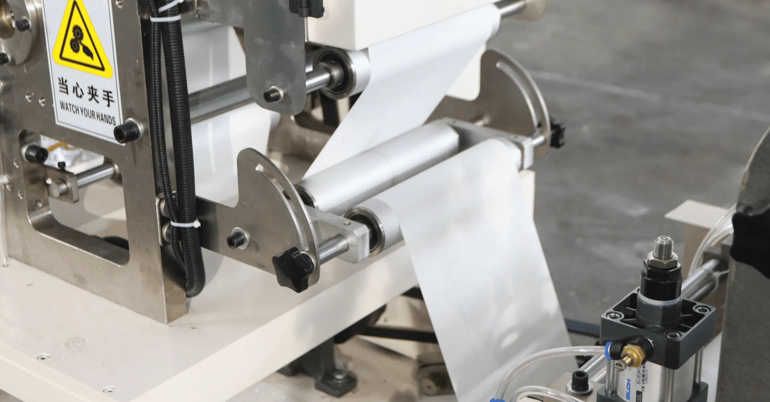 Guiding and alignment mechanism with servo-assisted roller positioning on a Welldone tissue line
