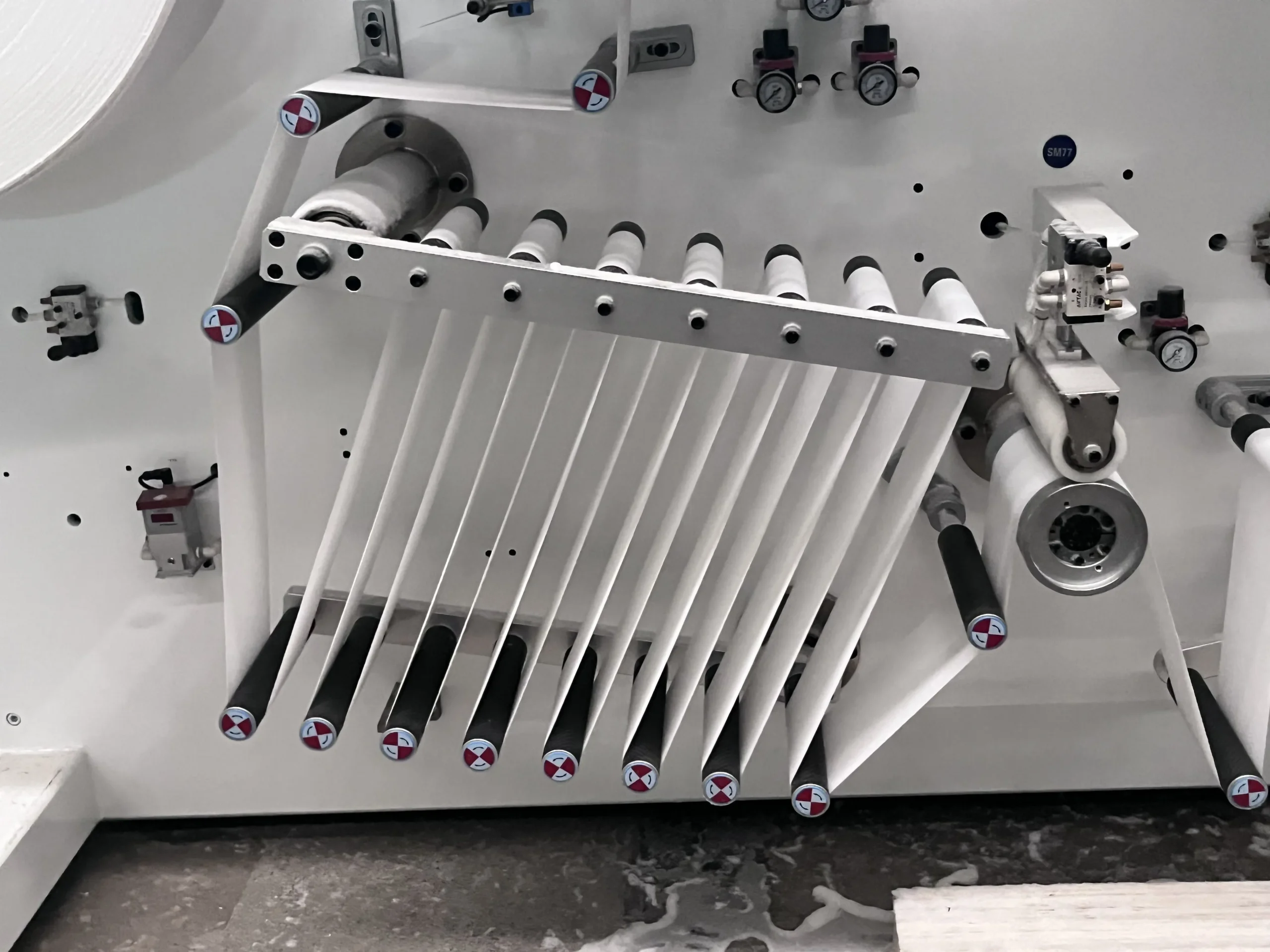 Non-woven and film master rolls staged near a Welldone sanitary napkin line — legacy lines require 4-6 weeks of safety stock; a matched servo line runs safely on 2 weeks