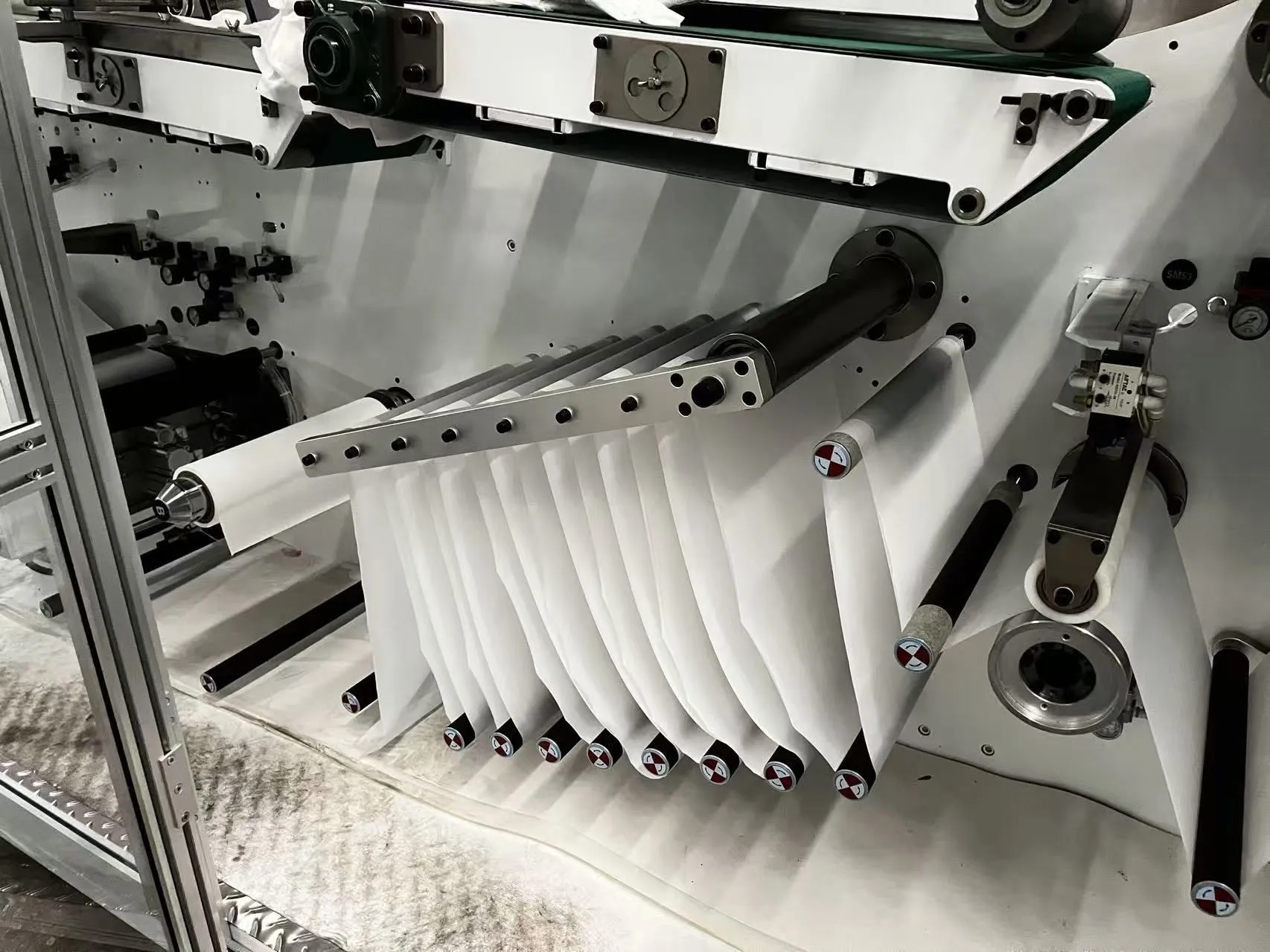 PE film wrapping and 90-degree turn station on a Welldone sanitary napkin line — the final quality gate where 0.8-1.5% of output on poorly matched lines becomes B-grade or scrap
