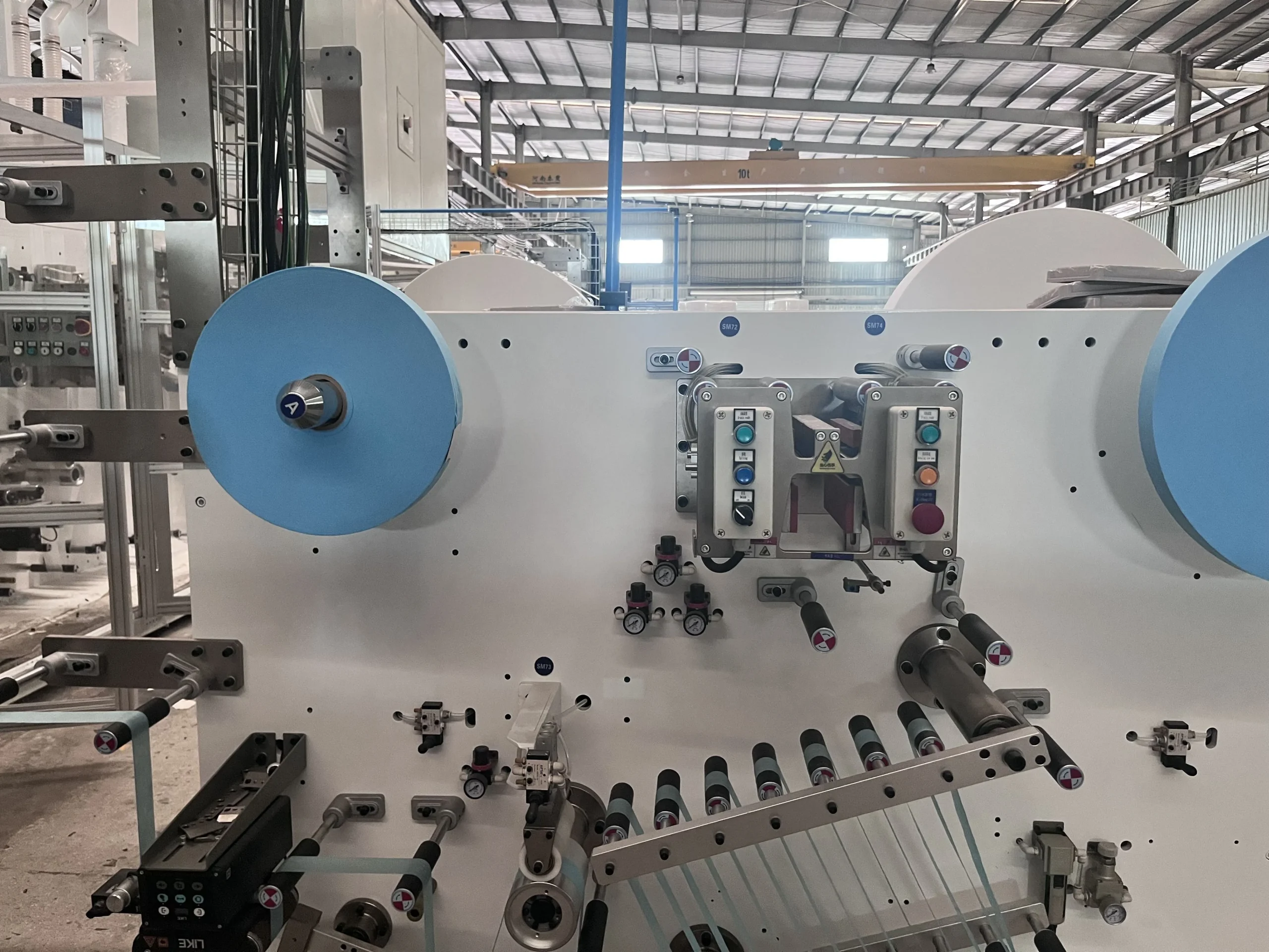 Pre-loaded non-woven roll magazine with automatic splice on a Welldone sanitary napkin line — collapses core roll changeover from 10 minutes to under 90 seconds