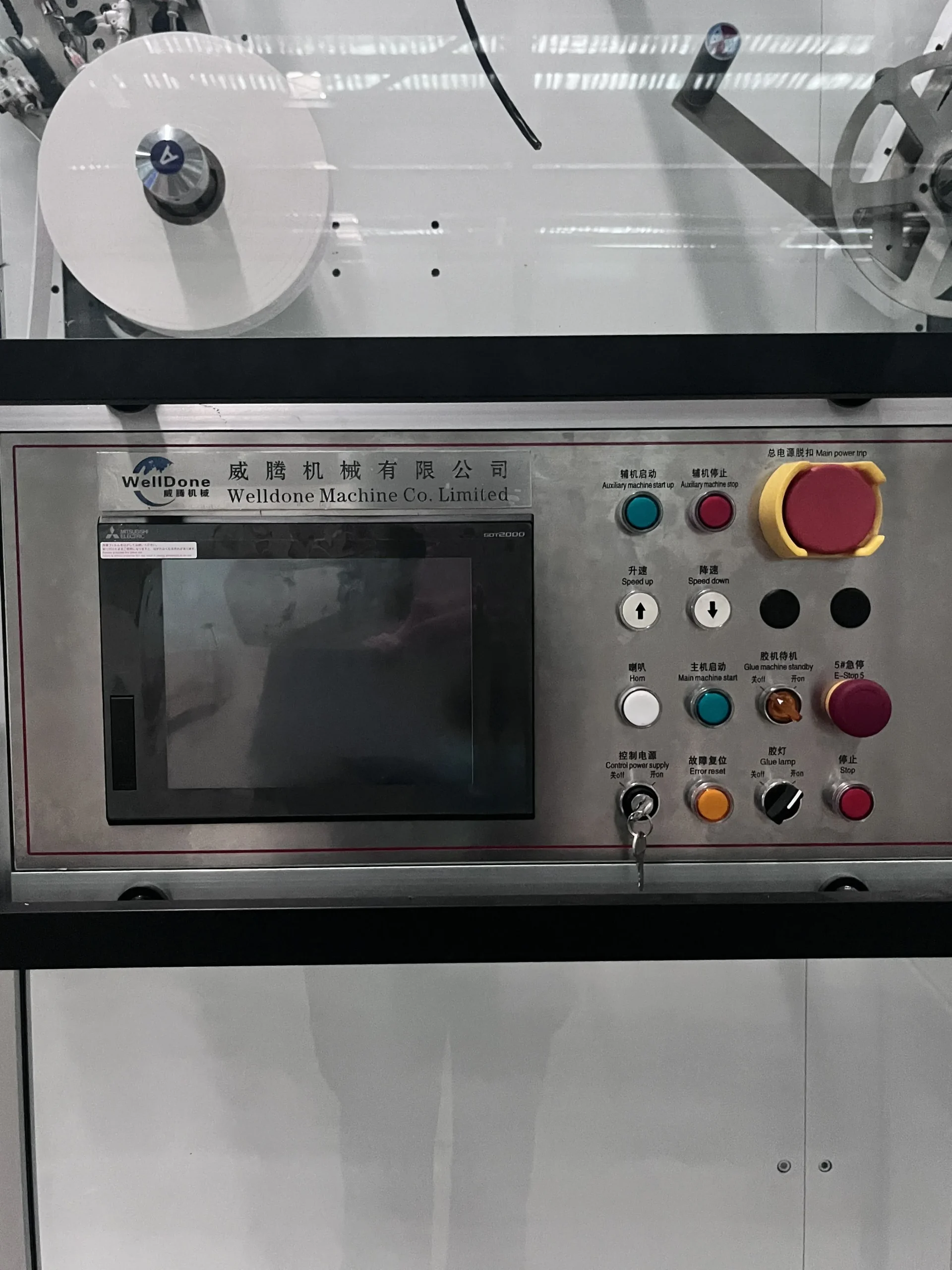 Mitsubishi GOT2000 recipe-based HMI touchscreen on a Welldone Machinery sanitary napkin line — stores up to 200 SKU parameter sets for one-touch changeover