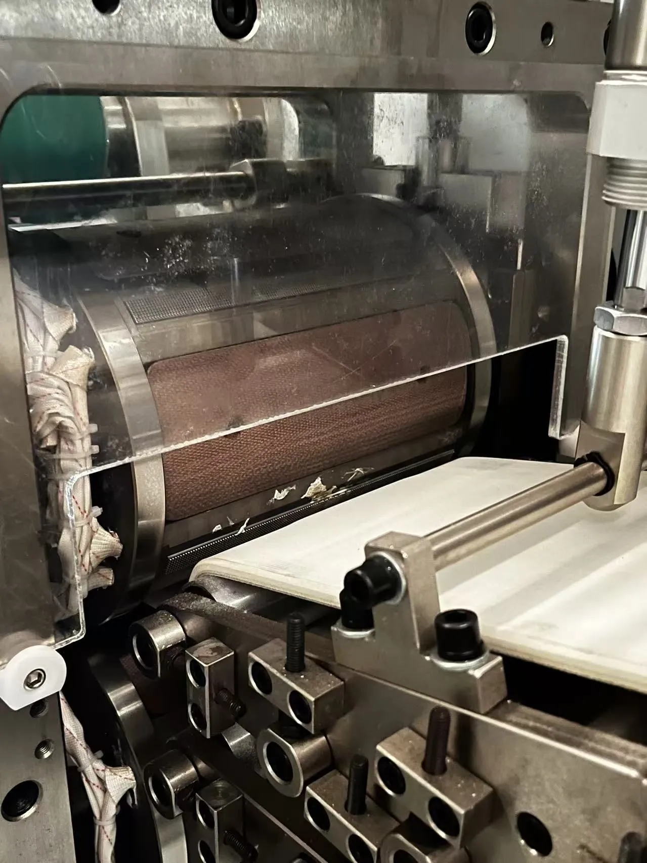 Servo-driven final cutting station on a Welldone sanitary napkin line producing a folded pad — pattern change is a stored parameter, not a mechanical cam swap