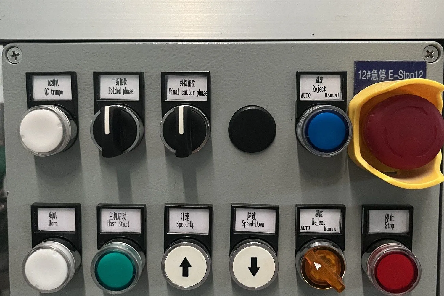 Operation panel of a baby diaper production line showing speed-up, speed-down, reject and stop controls