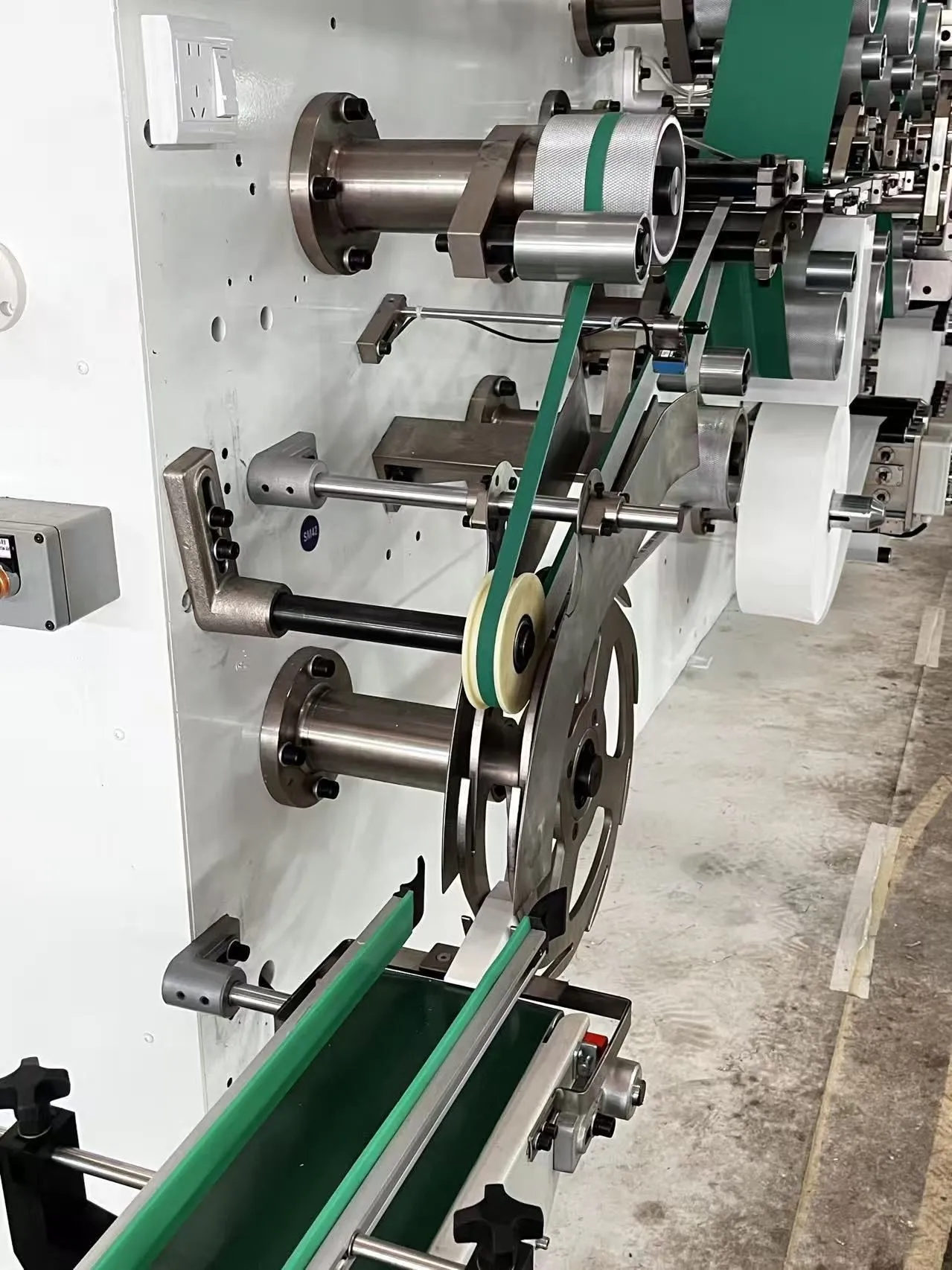 Finished under-pad output conveyor with automatic counting and stacking mechanism on a Welldone production line — the throughput stage that determines whether institutional daily consumption is met within a single shift