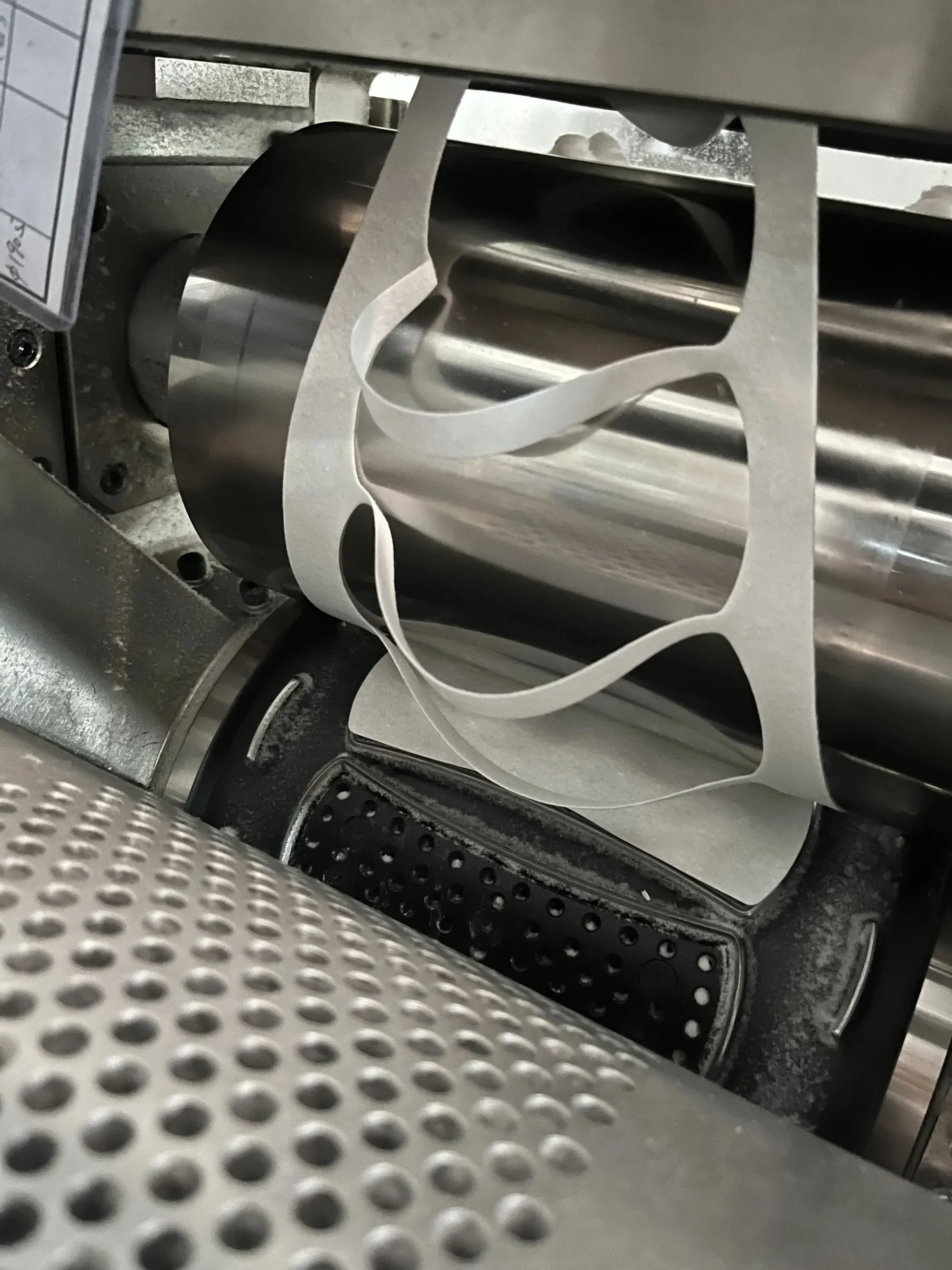 Rotary die cutter precision cutting under-pad absorbent core shapes on a Welldone production line — die cut edge quality directly affects whether the ADL and tissue inter-layers can be laminated within the dimensional tolerance required for EN 13795 medical-grade bedding protection