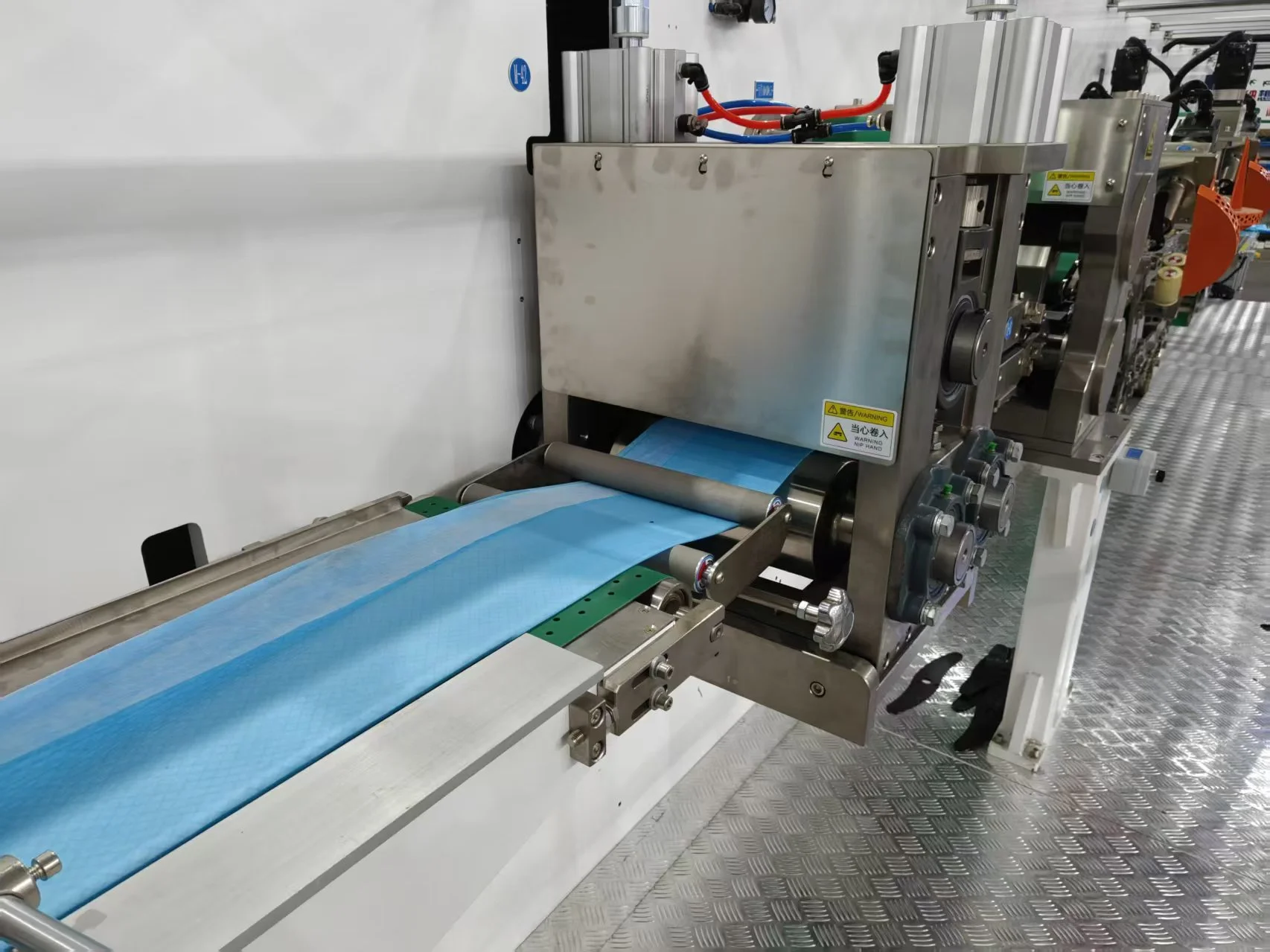 Nonwoven roll unwinding racks on a mattress machine