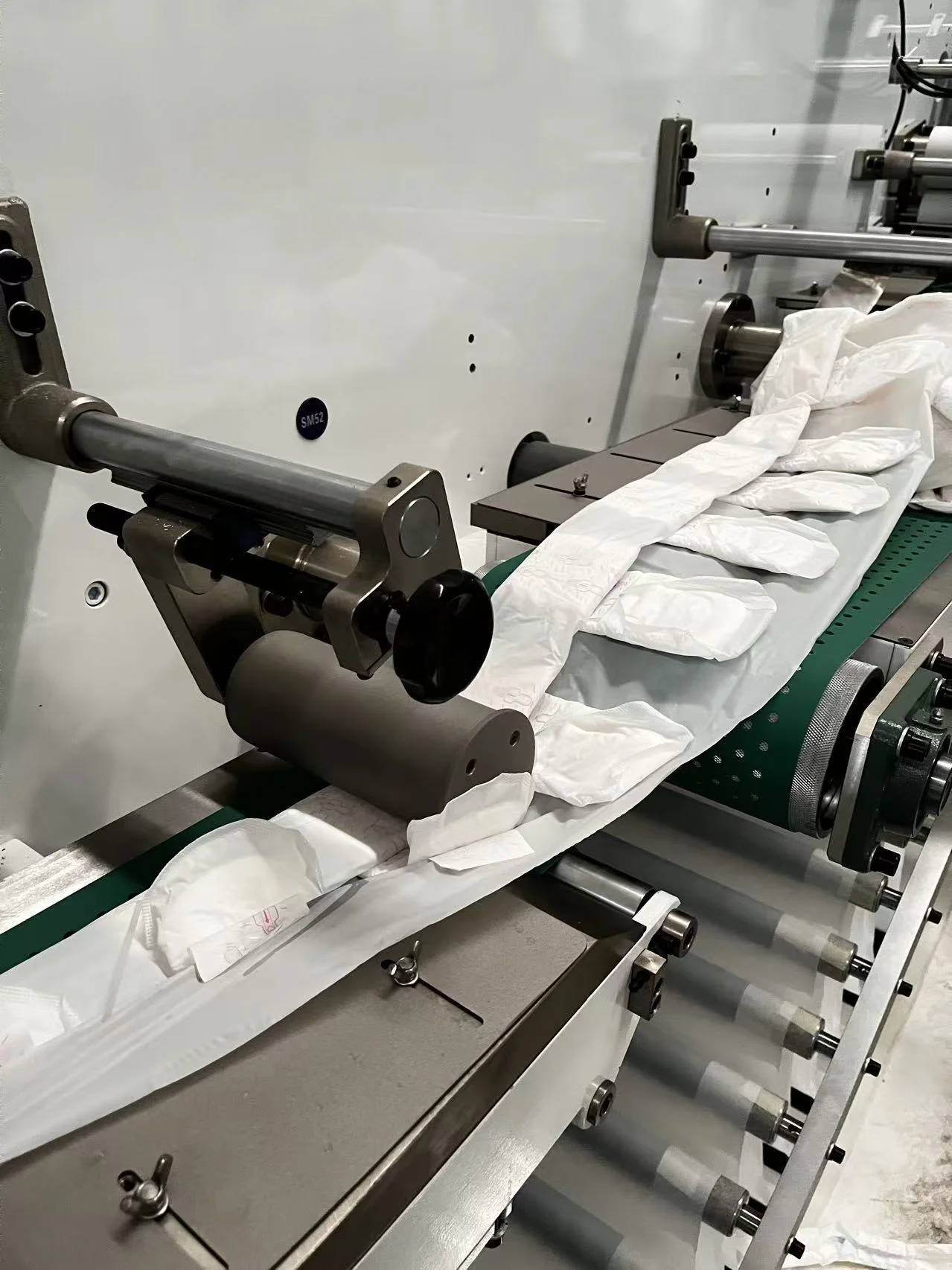 Sanitary pad folding station on a female care production line