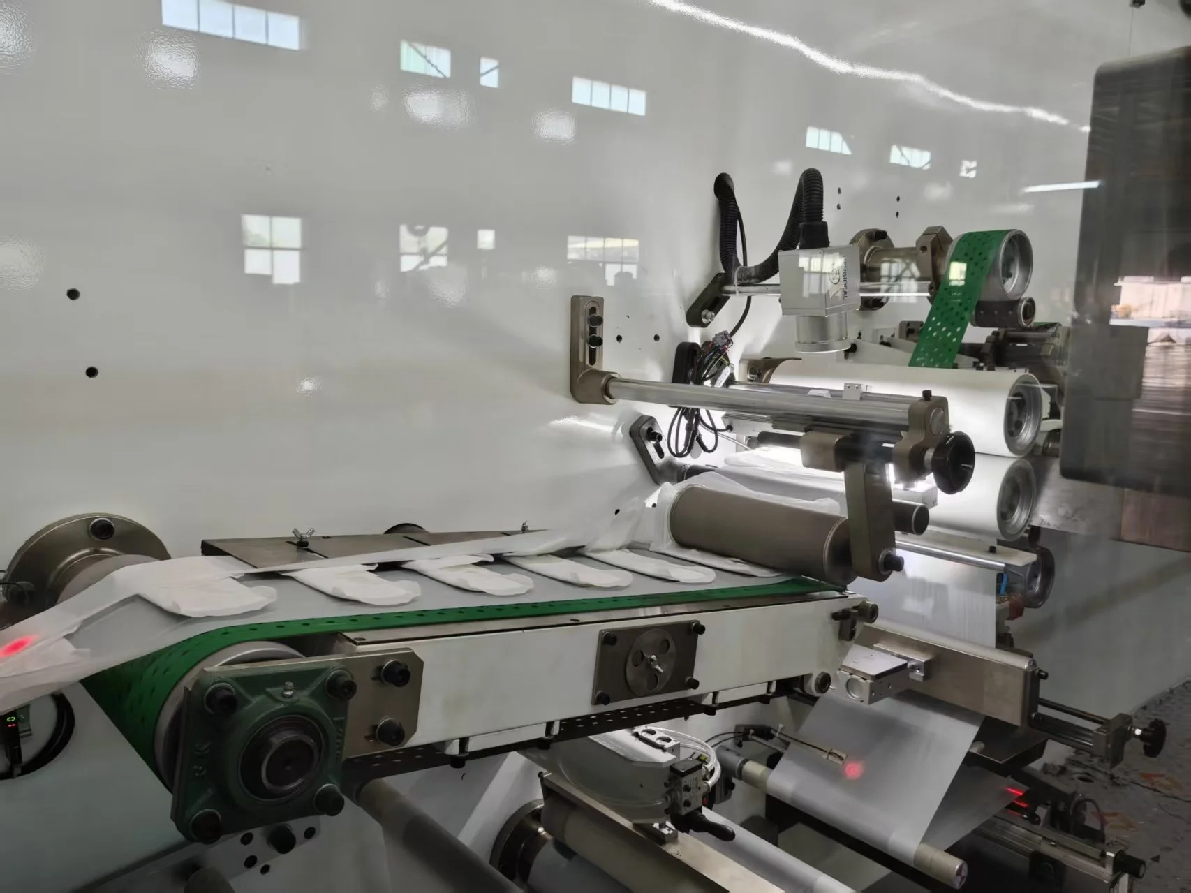 Panty liner downstream product transfer on a Welldone production line